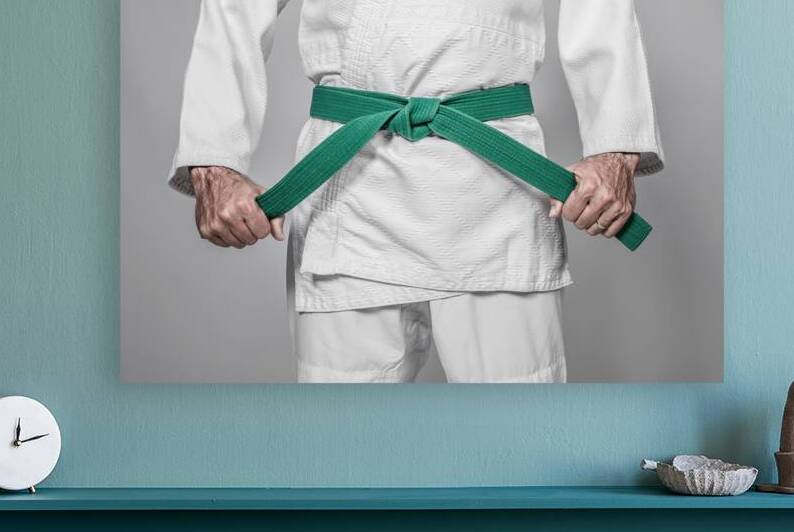martial arts practitioner tightening his belt  by Gualtiero Boffi
