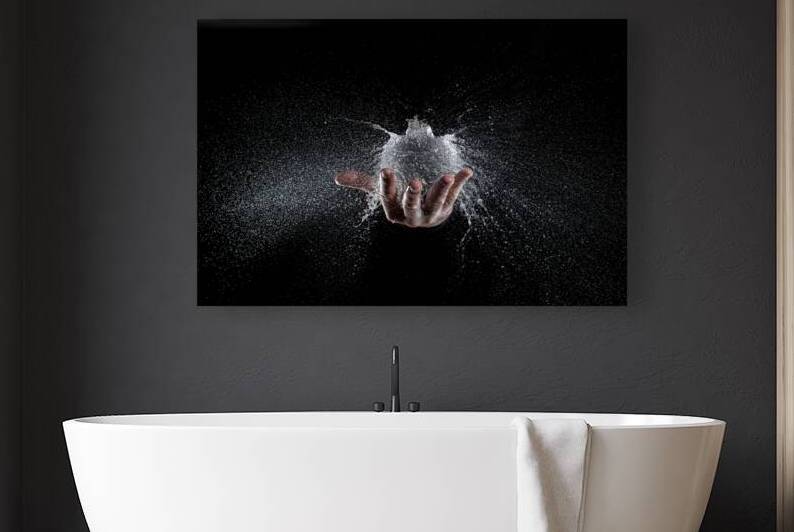 explosion of a balloon full of water held on a hand black backg by Gualtiero Boffi