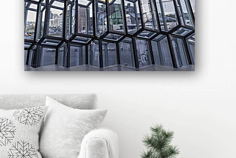 Modern geometric glass facade reflecting cityscape in reykjavik by Gualtiero Boffi