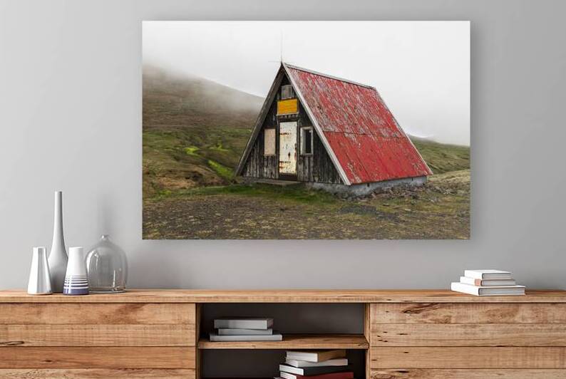 Old abandoned wooden hut with red roof standing on green hillsid by Gualtiero Boffi