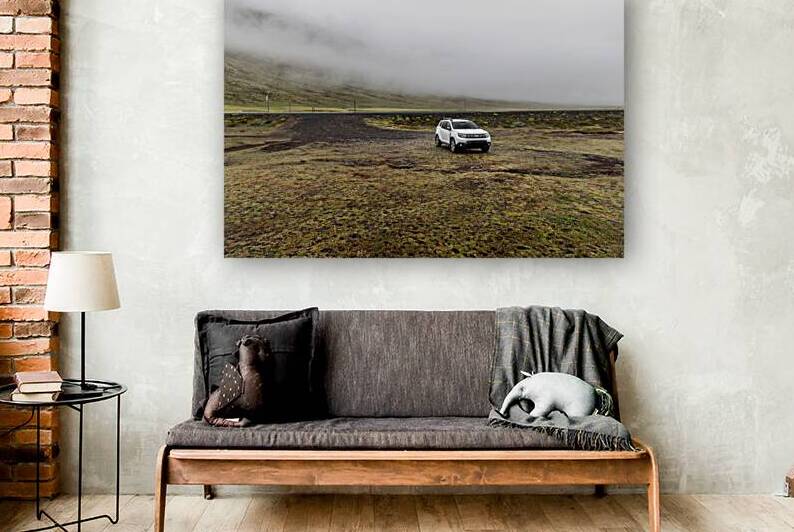 White suv parked on side of empty road leading into foggy mounta by Gualtiero Boffi