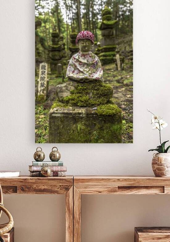 Ancient jizo statue wearing a knitted hat and bib sitting in a c by Gualtiero Boffi