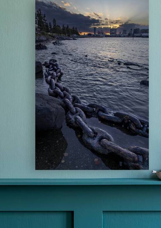 Old rusty chain lying on a rocky beach at sunset by Gualtiero Boffi