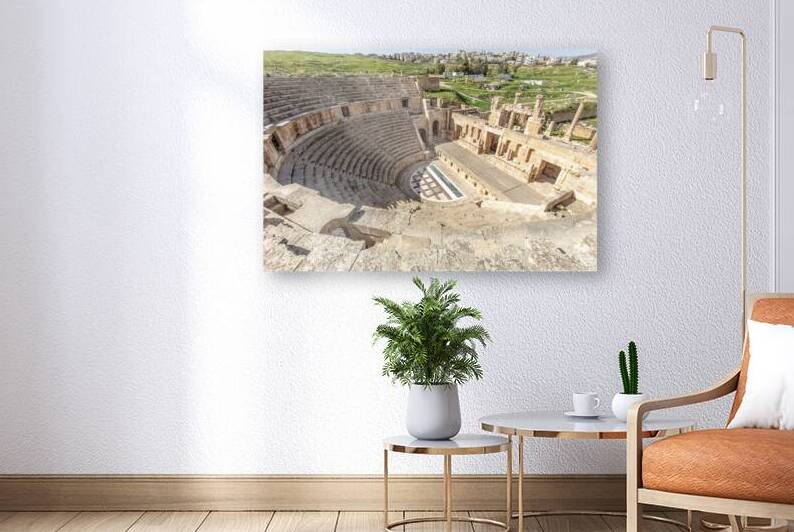 Stone seating and stage of jerash roman theatre with modern city by Gualtiero Boffi