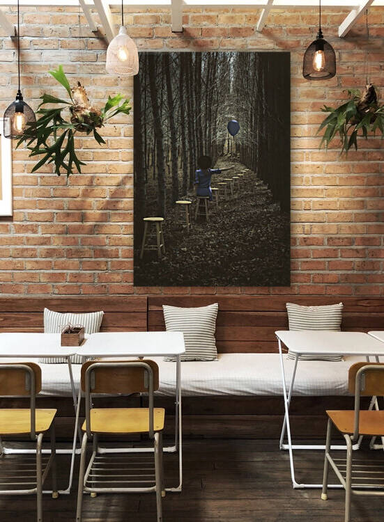 Rear view of a woman holding a purple balloon in a dark forest sitting alone in a row of wooden stools by Artmood Visualz