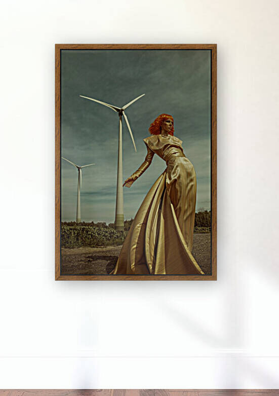 Portrait of a beautiful young woman with an orange bob haircut wearing a long shiny golden dress standing in front of a corn field and wind turbines on a sunny day by Artmood Visualz