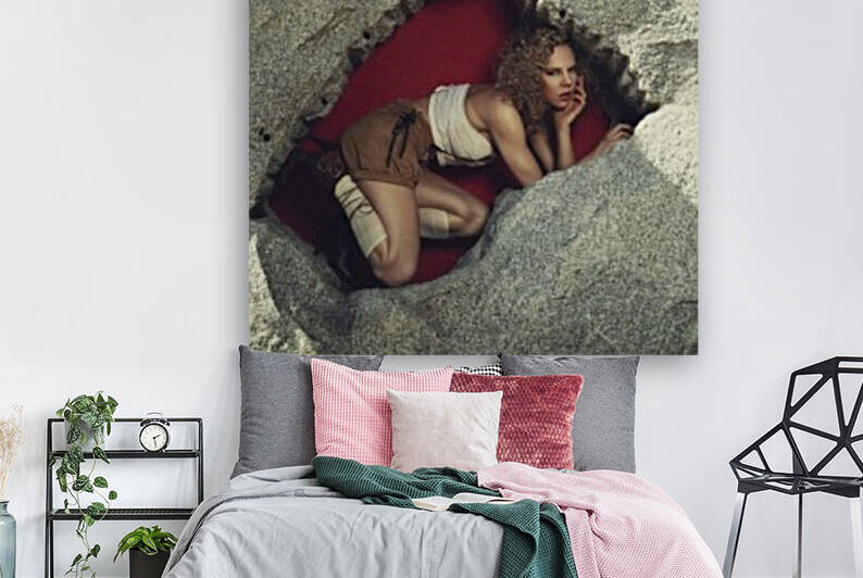 Beautiful curly blonde woman wearing an oktoberfest style outfit posing in a rock hole with a red background by Artmood Visualz