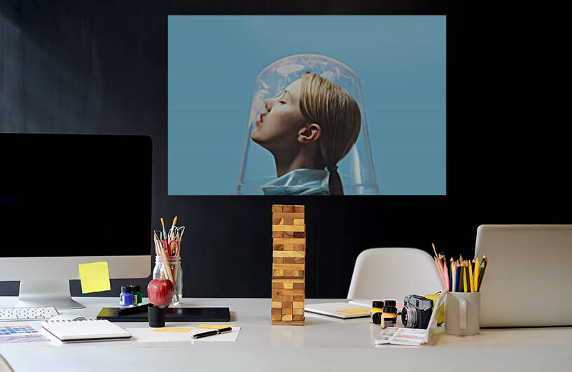 Side view of the head of a young blonde woman trapped in a clear bell blowing smoke  by Artmood Visualz