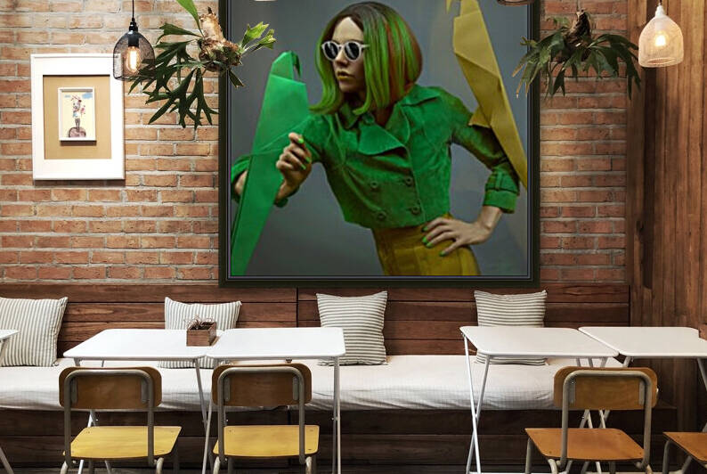 Portrait of a beautiful young fashion model wearing sunglasses a green jacket and a green bob haircut posing with two origami parrots in front of a grey background by Artmood Visualz