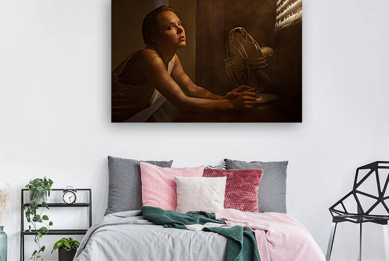 Young woman in a white tank top suffering from the heat sitting in front of an old fan with louver lighting by Artmood Visualz