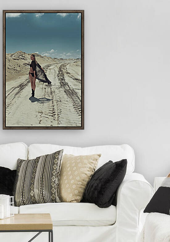 Beautiful young blonde woman in a black swimsuit walking in the sand of a desert on a sunny day turning aroung to look at the camera by Artmood Visualz