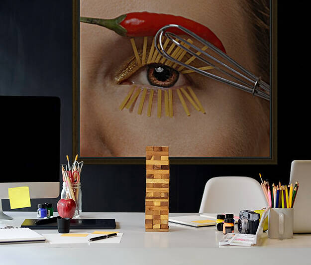 Close-up of a womans brown eye with a whisk as a mascara applicator and spaghetti pastas as eyelashes her eyebrow made of a red hot pepper by Artmood Visualz
