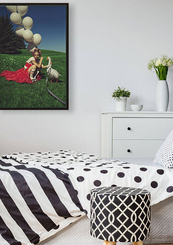 Beautiful young blonde woman wearing a traditional Dutch inspired pink dress holding a bunch of white balloons while basking under the summer sun with a goose on leash in a green valley  by Artmood Visualz