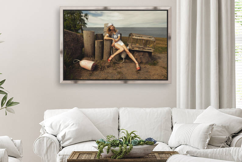 Attractive young blonde woman wearing a sailor style outfit sitting on wooden pillars in a lobster fishermans cove by Artmood Visualz