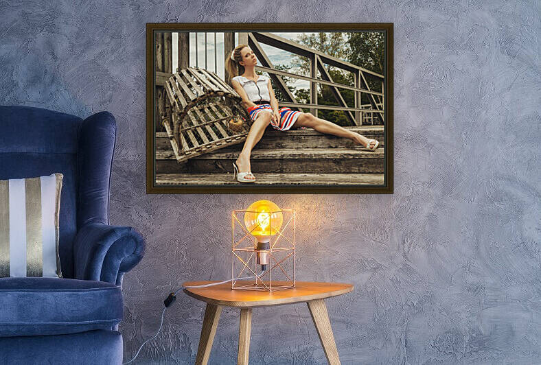 Attractive young blonde woman in a summer dress sitting on stairs beside a lobster cage by Artmood Visualz
