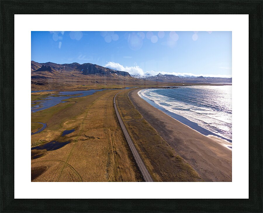 Iceland scenic route Snaefellsnes pensinsula volcano in the background covered in snow empty road with the ocean and waves. Picture Frame print