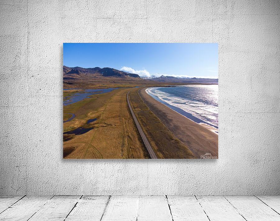 Iceland scenic route Snaefellsnes pensinsula volcano in the background covered in snow empty road with the ocean and waves. Wall Preview
