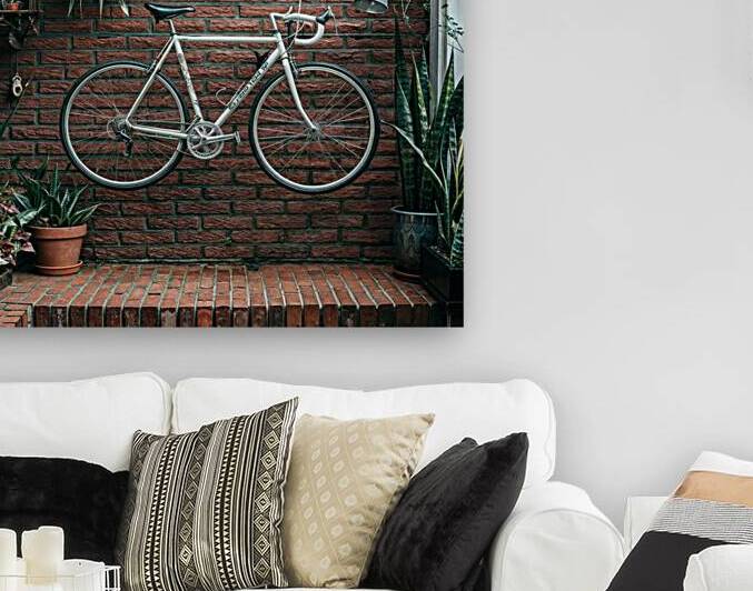 bicycle handing on a red brick wall by rassam