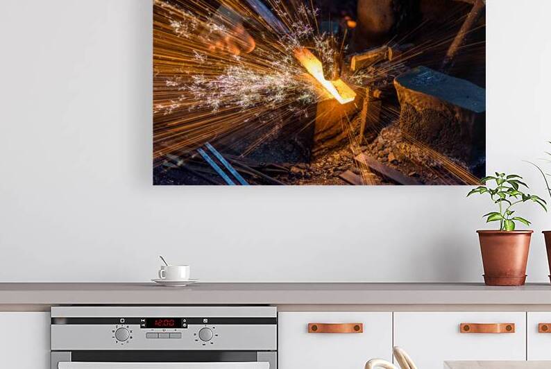Blacksmith forging the molten metal on the anvil with spark fireworks by Mirko Kuzmanovic