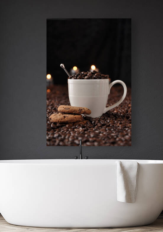 Coffee beans in white mug next to chocolate chip cookies and candles on black background by Thevectoryfloor
