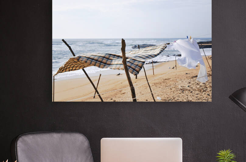 Clothes on clothesline drying in the sun on beach in Vila do Conde Portugal by Thevectoryfloor