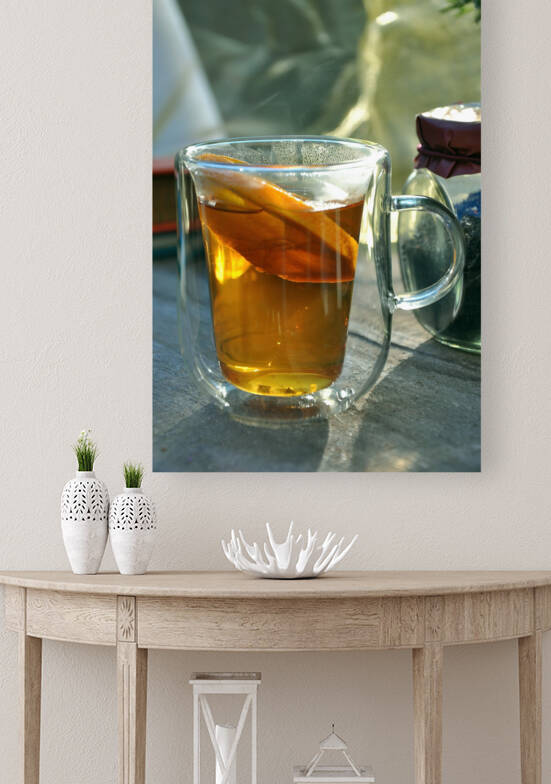 Close-up of hot tea in glass cup on wooden table during golden hour by Thevectoryfloor