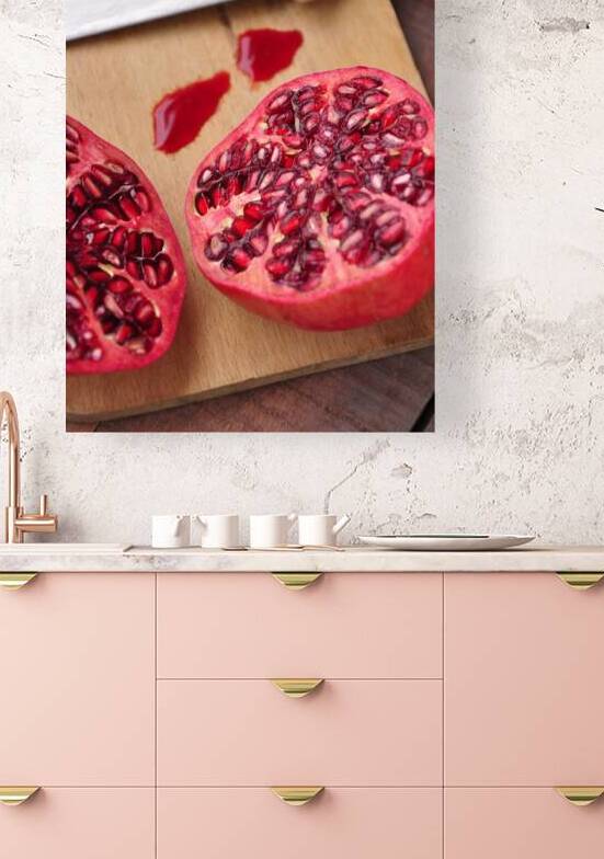 Close-up of halved pomegranate on cutting board next to kitchen knife by Thevectoryfloor