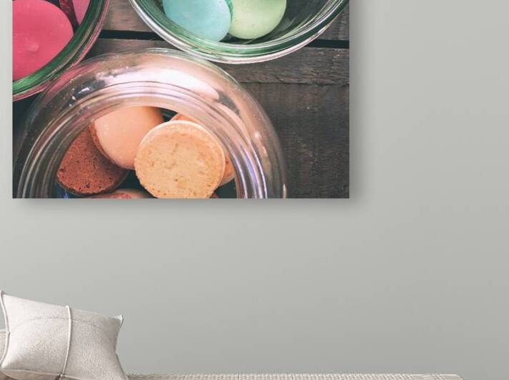 Close-up of multi colored macarons in glass jar on wooden table by Thevectoryfloor