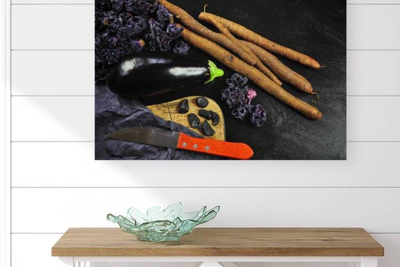 Directly above shot of eggplant and salsify on black wooden table by Thevectoryfloor