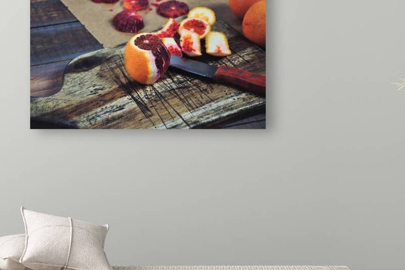 High angle view of halved blood orange on wooden cutting board by Thevectoryfloor