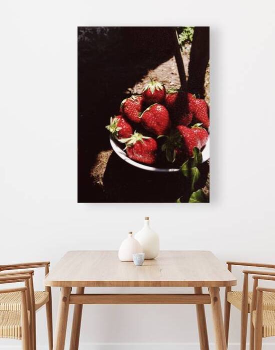 Close-up of fresh strawberries in bowl on stone table during picnic by Thevectoryfloor