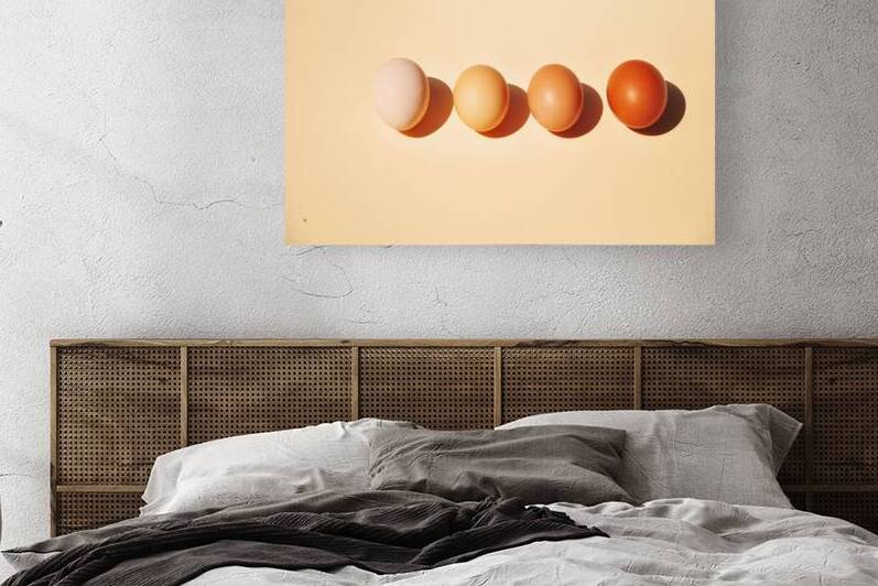 High angle view of four brown eggs in a row on beige background by Thevectoryfloor