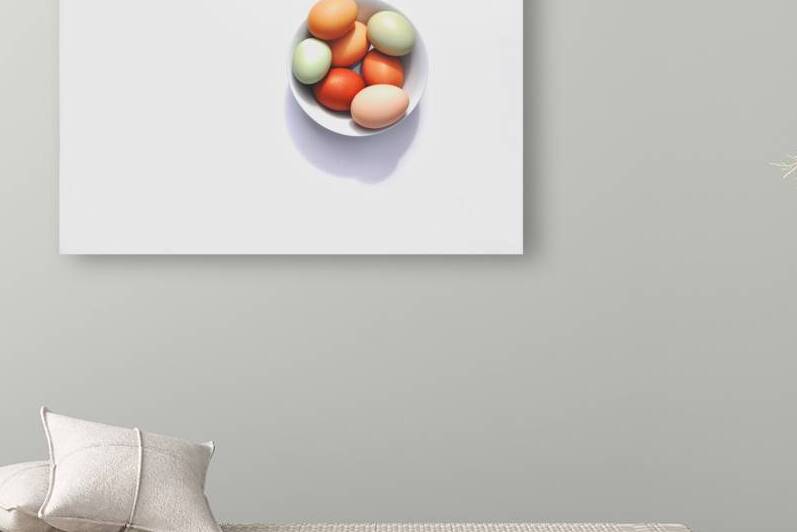 Directly above shot of white bowl with multi colored eggs on white background by Thevectoryfloor