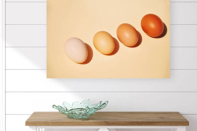 High angle view of four brown eggs in a row on beige background by Thevectoryfloor