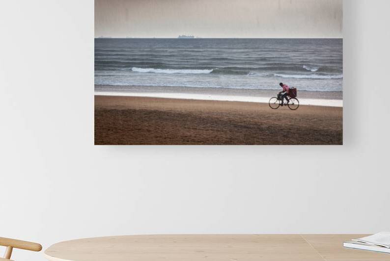 Boy speeding on bicycle under rain on beach Goa by Dmitry Rukhlenko