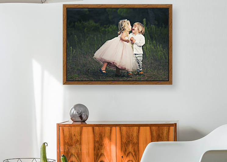 A young girl with a pink princess dress leans in to kiss a young boy; Tarifa, Cadiz, Andalusia, Spain by PacificStock