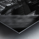 Black and white street photo of people walking down the road seen through the spokes of a bicycle Metal print