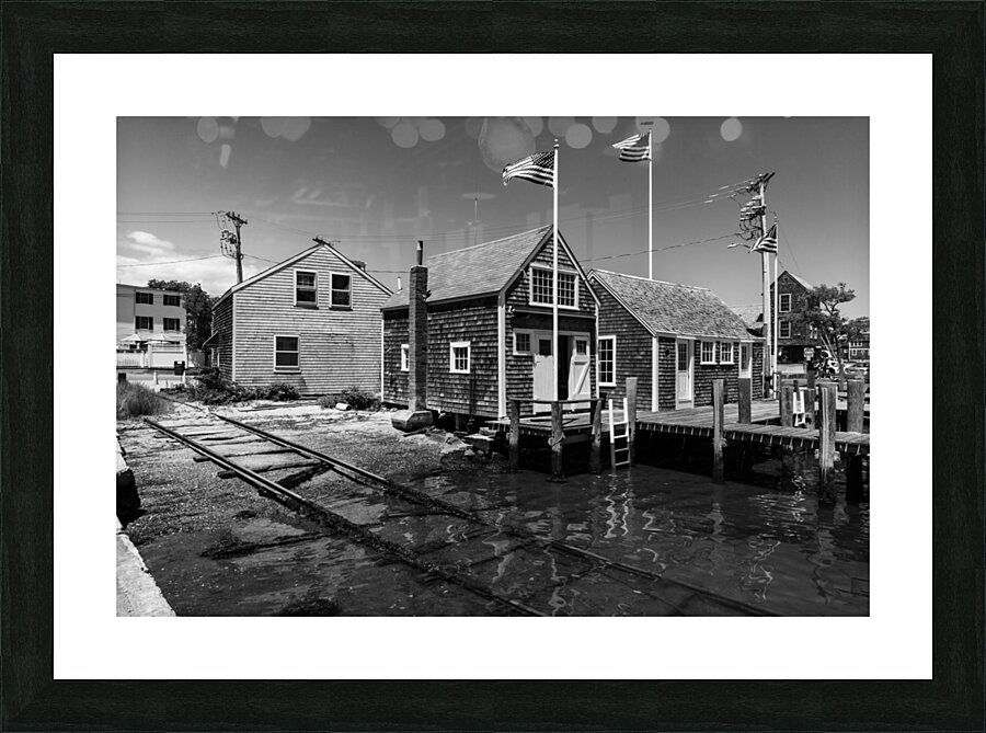 Black and white shot of historic harbour buildings and boat ramp on Cape Cod in New England  Picture Frame print