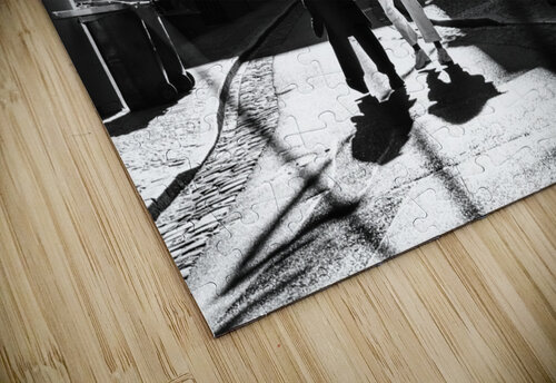 Black and white street photo of people walking down the road seen through the spokes of a bicycle caladoart puzzle