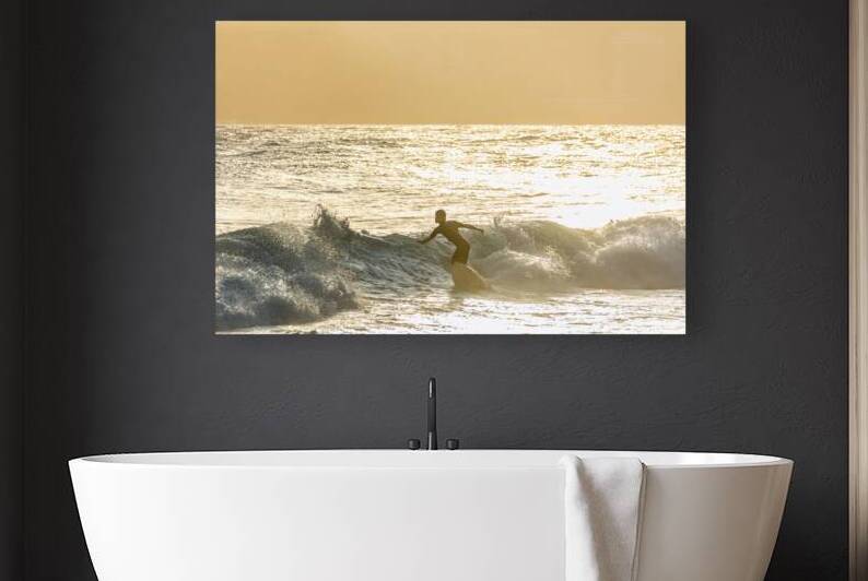 Surfer riding the waves at Ipanema Beach in Rio de Janeiro in Brazil at sudown by caladoart