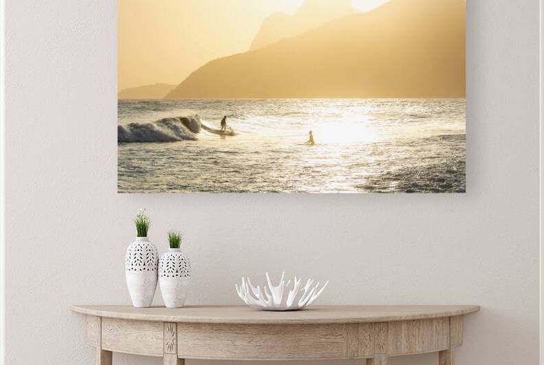 Surfers riding the waves in front of scenic hills at Ipanema Beach in Rio de Janeiro in Brazil at sunset  by caladoart