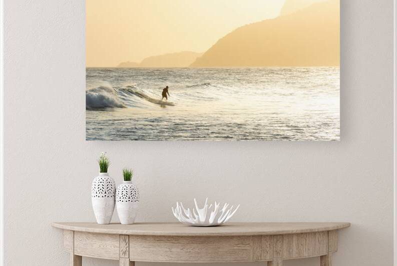 Surfer riding the waves in front of scenic hills at Ipanema Beach in Rio de Janeiro in Brazil at sunset  by caladoart