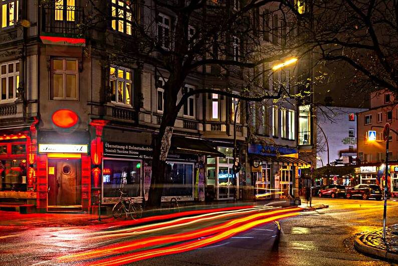 Long exposure night shot of a colourfully lit up streetcorner in Hamburg Altona by caladoart