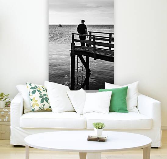 Black and white shot of man taking a cigarette break on a pier at the Baltic Sea by caladoart