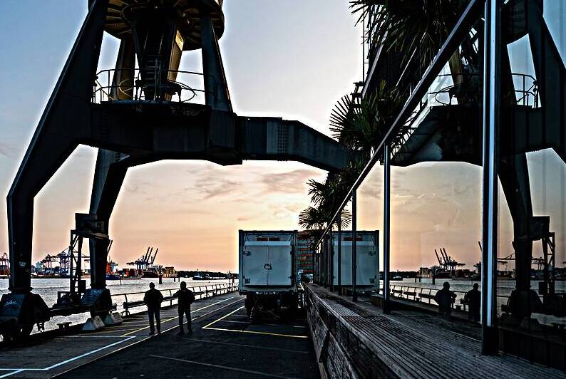 Historic crane and people at the Dockland waterfront in Hamburg by caladoart