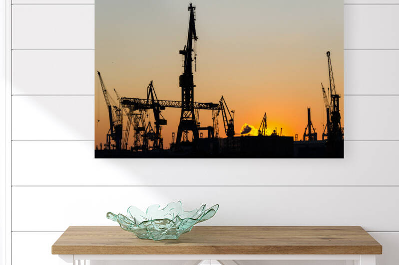 Harbour cranes in Hamburg during a beautiful orange sunset  by caladoart