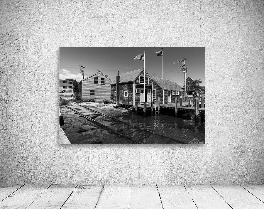 Black and white shot of historic harbour buildings and boat ramp on Cape Cod in New England  Wall Preview