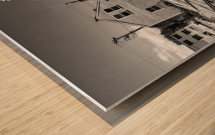 Black and white shot of historic harbour buildings and boat ramp on Cape Cod in New England  Wood print