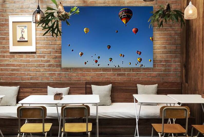 Colorful hot air balloons flying in a clear blue sky during a fe by Gestalt Imagery