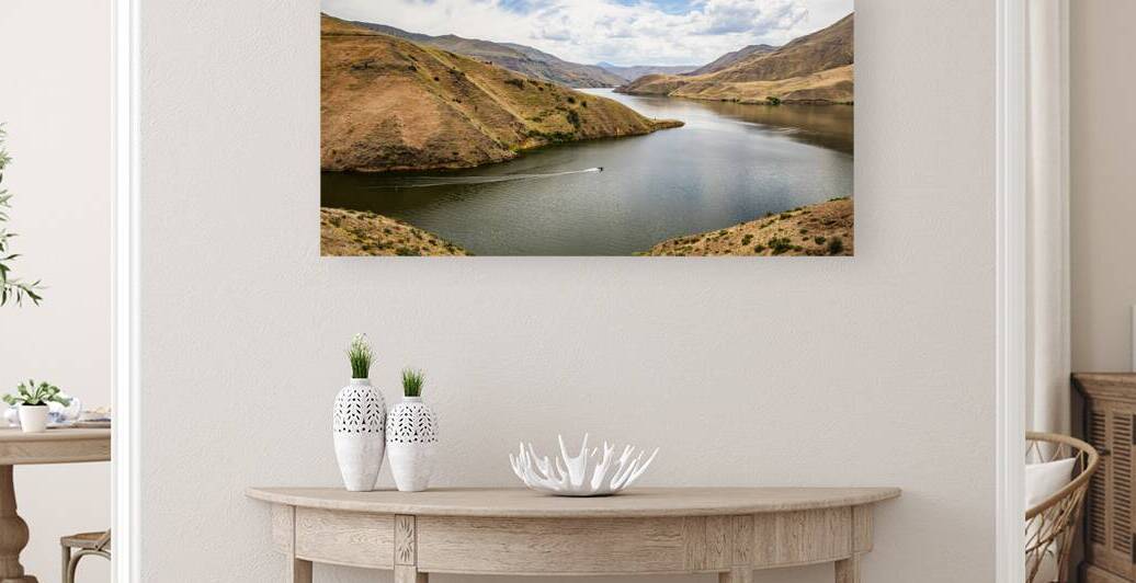 Boater navigating the scenic Snake River amidst arid hills and c by Gestalt Imagery
